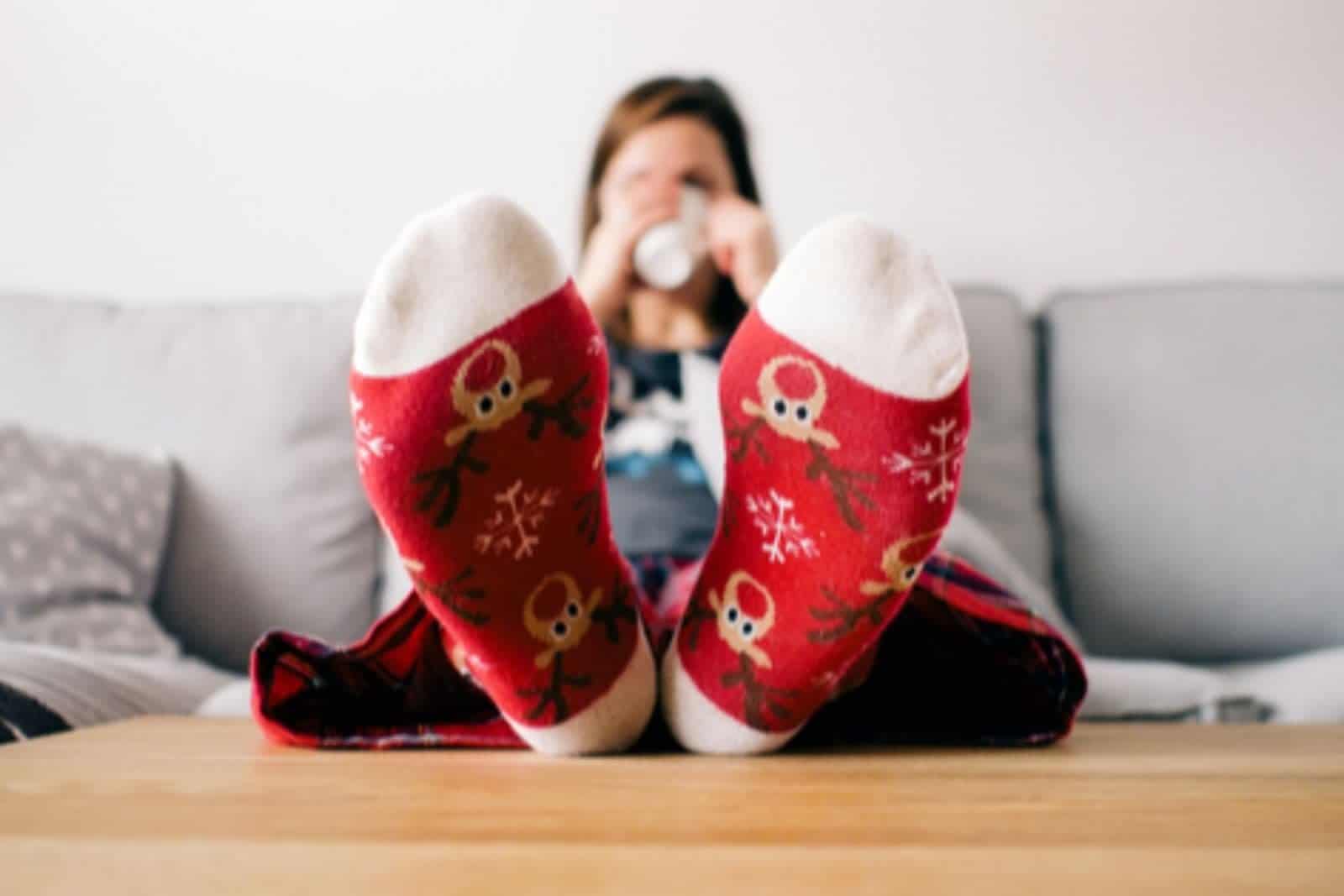 Mom in Christmas socks sitting down to enjoy the holidays