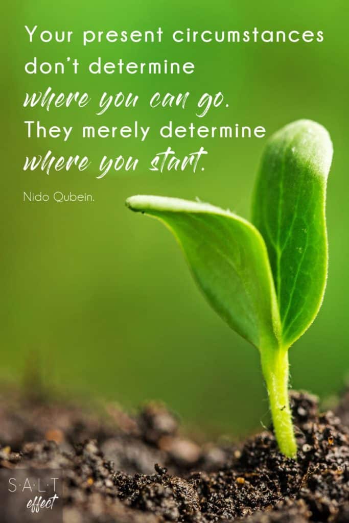A new beginnings quotes pin: "Your present circumstances don't determine where you can go. They merely determine where you start." Quote by Nido Qubein in white text on a green background. A small green leaf is growing from the dirt.