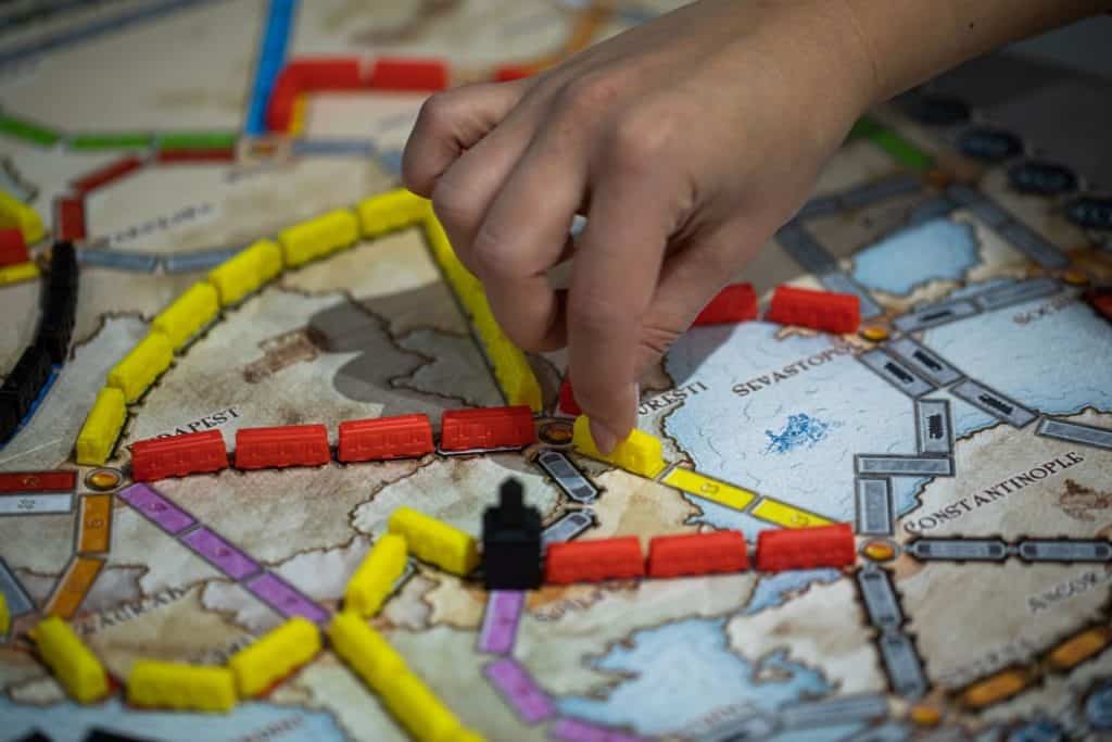 Person playing the great board game for teenagers Ticket to Ride