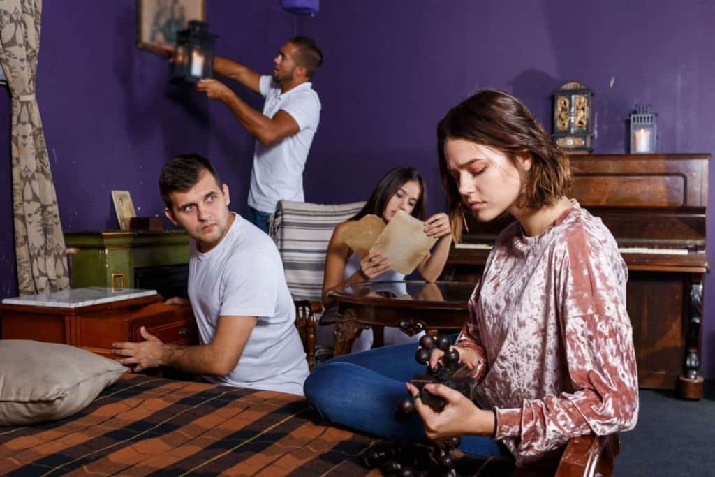 four people looking around a room as part of an escape room experience