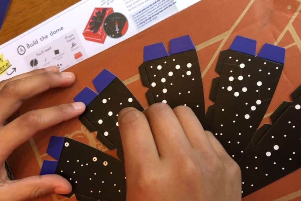 a boys hands doing a Kiwi Crate project