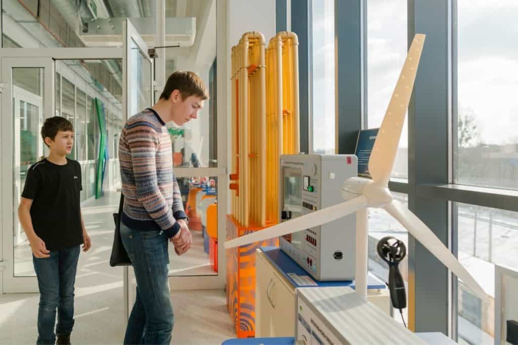 two boys looking at a propeller at a science museum