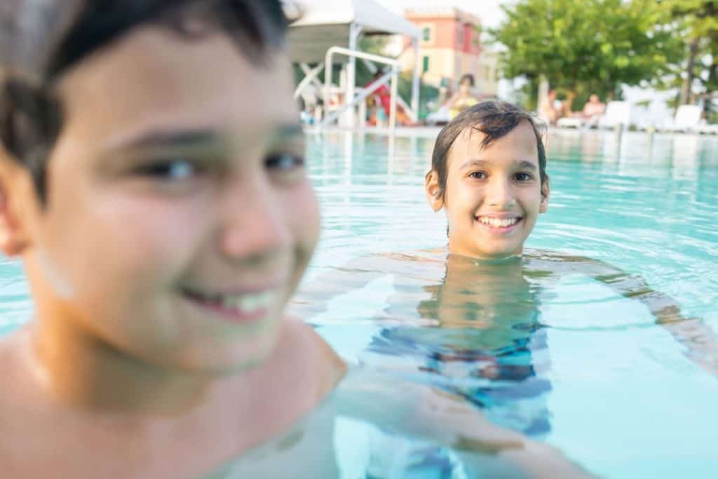 boys in a swimming pool smiling