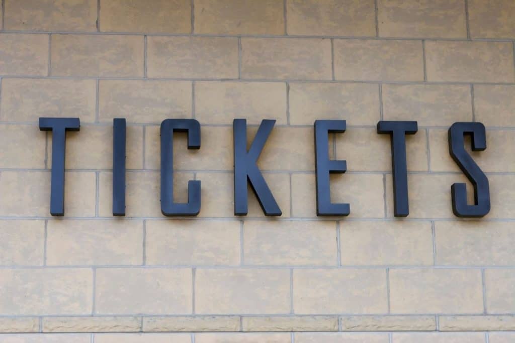 picture of a tickets sign on the side of a brick wall