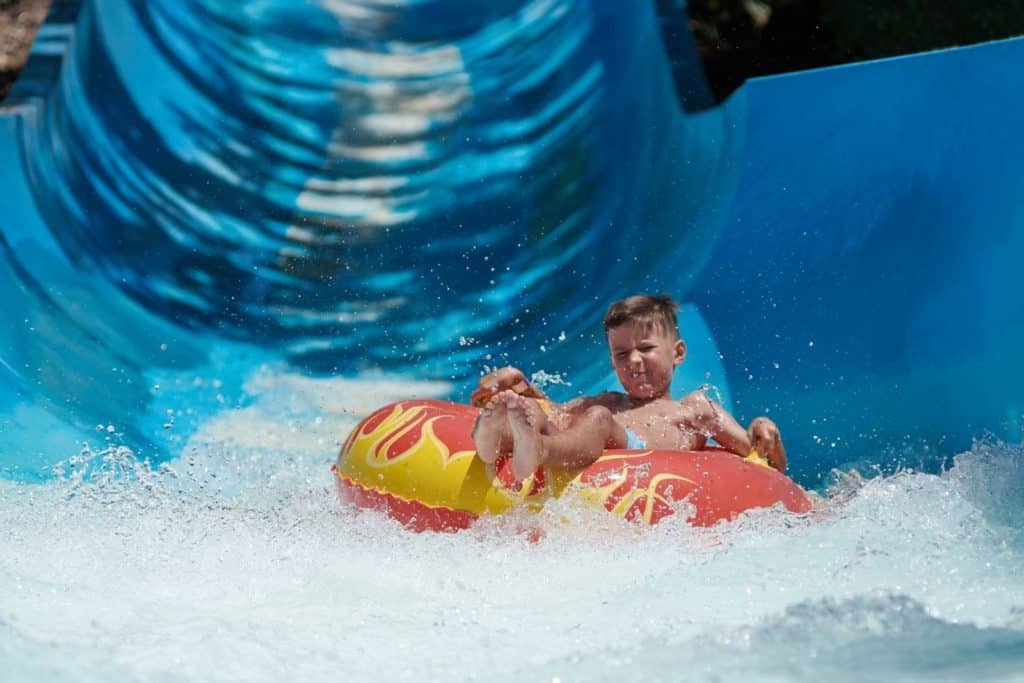 boy riding a tube down a waterslide at a waterpark