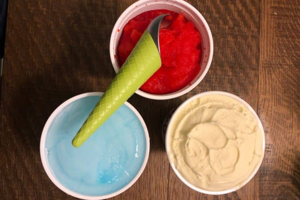 three colors of italian ice and an ice cream scooper