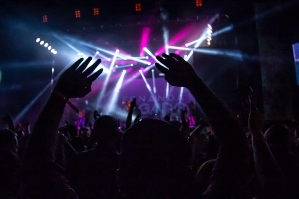 hands raised and spotlights at a concert