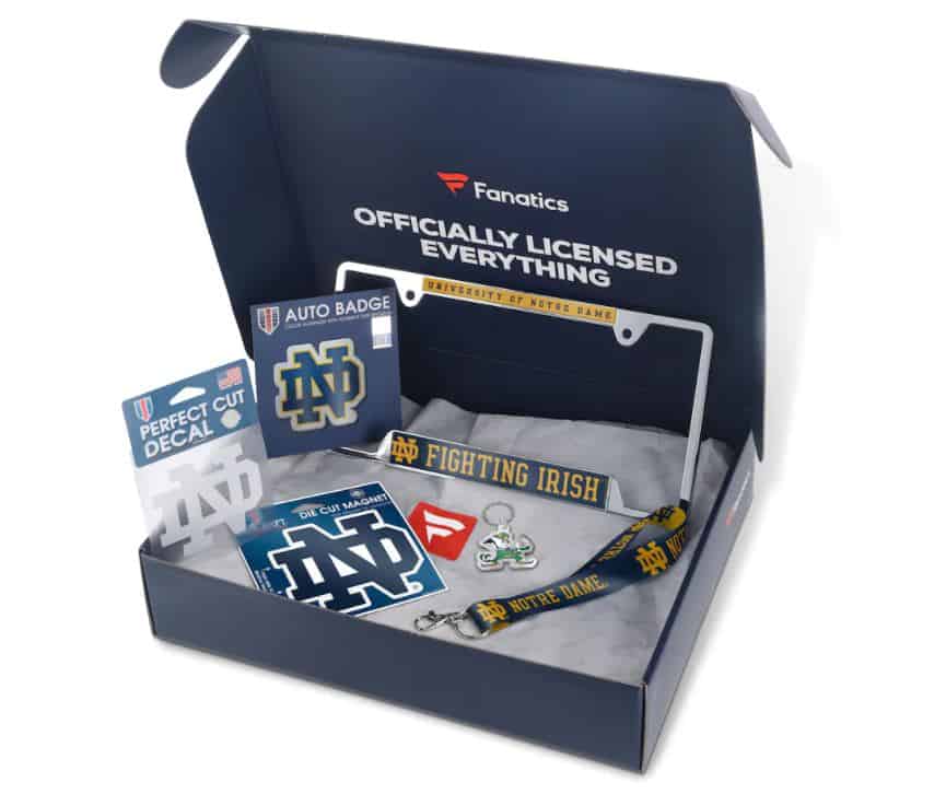 Open gift box of Notre Dame officially licensed automotive items from Fanatics. Includes a license plate frame, stickers, keyring, keystrap and magnet.