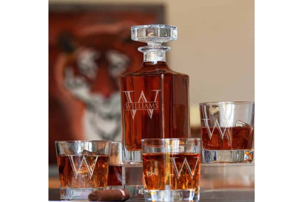 Personalized whiskey decanter and four rocks glasses. Decanter has Williams engraved in all capital letters in front of a W. Rocks glasses have an engraved capital W.