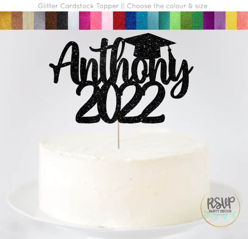 Custom cake topper for 2022 8th grade graduates. Anthony 2022 is in script font on black glitter card stock with a graduation cap. Other color options are in a row at the top of the image.