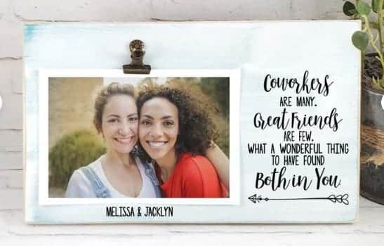 Handmade wood frame painted a soft teal leaning on a counter. Photo of two smiling women under an antique clip on left side of horizontal frame with "Meliss & Jacklyn" below. One right side of frame in black font with arrow below: Cowokers are many. Great friends are few. What a wonderful thing to have found both in you.