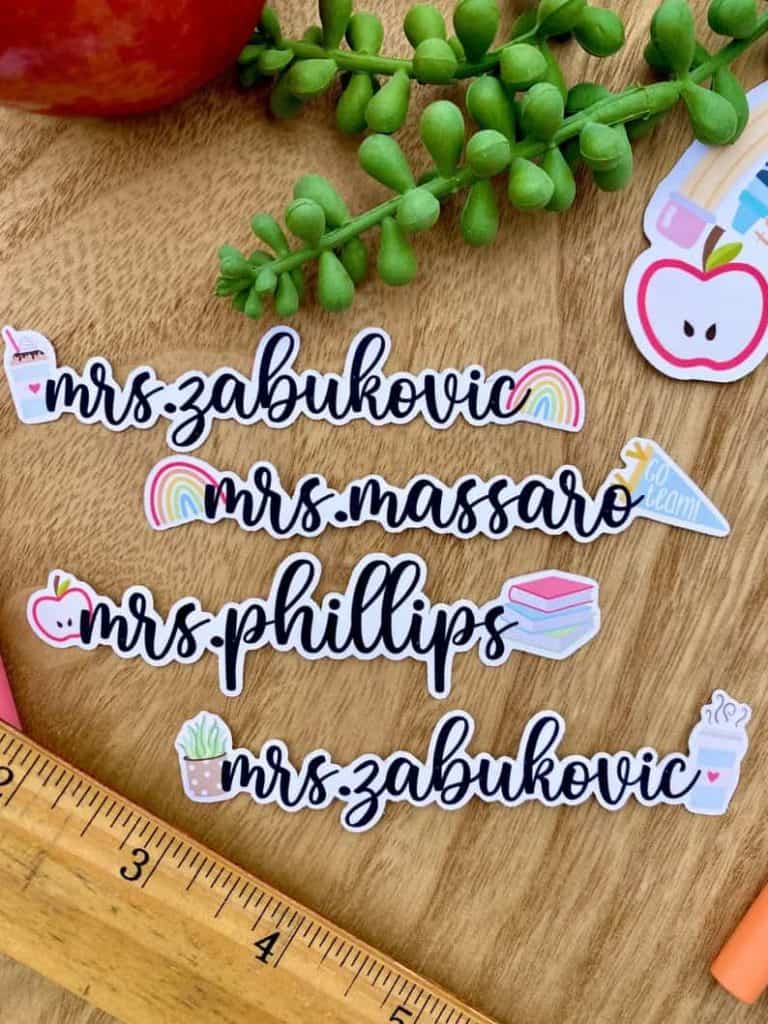 Personalized name laptop stickers for teachers. Mrs. Zabukovic with a coffee cup and rainbow. Mrs. Massaro with a rainbow and pennant. Mrs. Phillips with an apple and stack of books. Mrs. Zabukovic with a succulent and coffee cup.