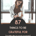 Pinterest pin that says "87 things to be grateful for [gratitude journal prompts]" on the bottom half. Black background with peach and tan words. Top half of pin is a woman with short dark hair and glasses writing in a journal as she sits on a wooden bench with a cup of coffee. Behind her is a huge window.