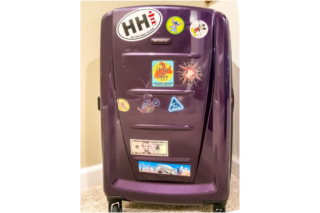 Purple Samsonite hardside luggage with stickers from tween and teen travels